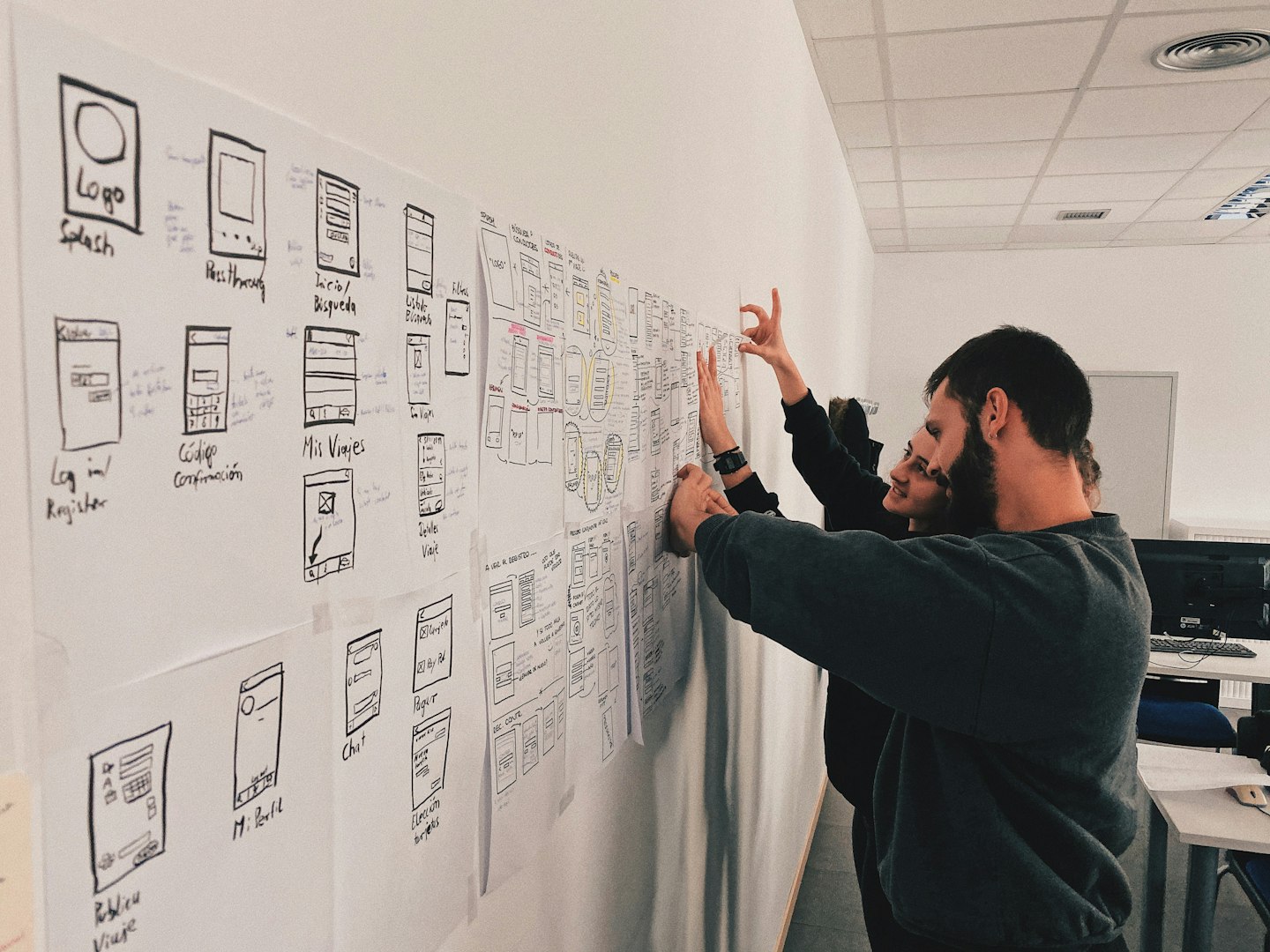 A friendly, high-level illustration showing a person standing before a large blueprint that is transforming into a glowing digital interface.